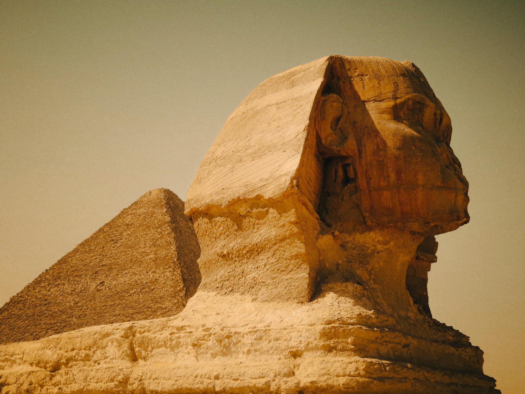 great sphinx and pyramid under autumn sky